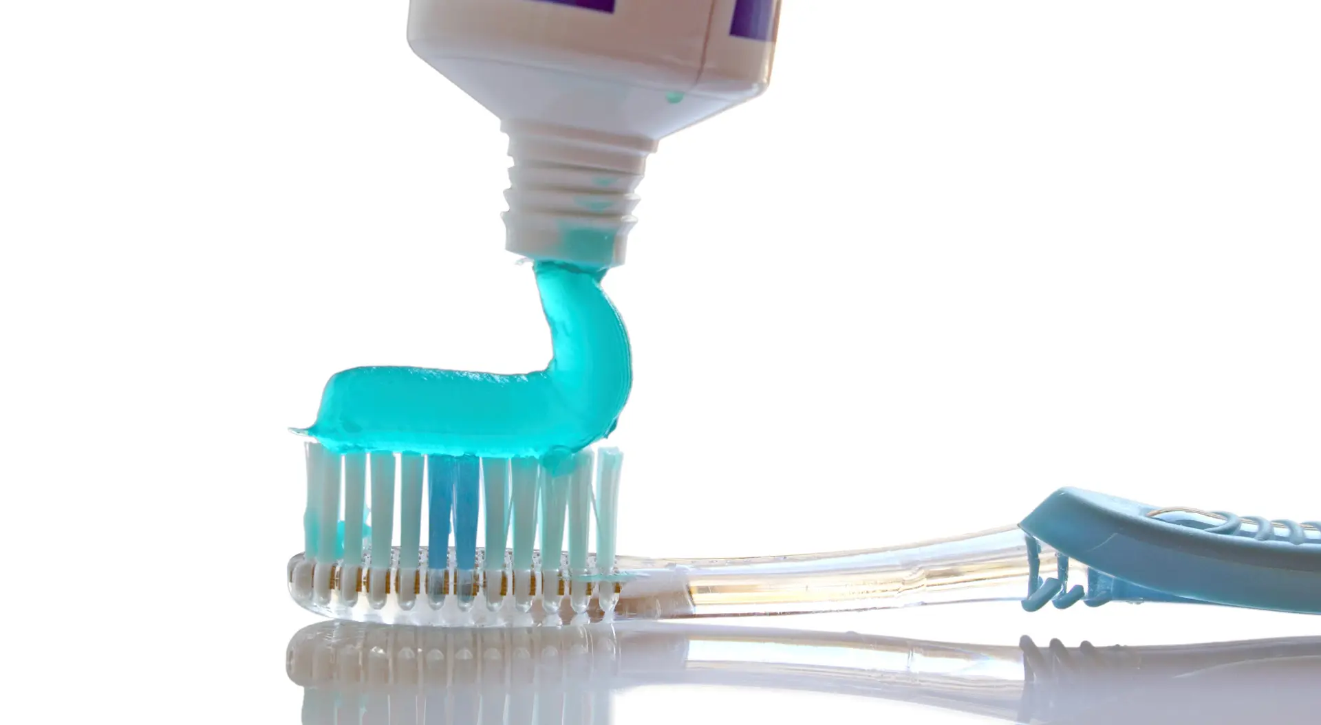Fluoride 1 A close-up view of toothpaste being applied to the head of a toothbrush.