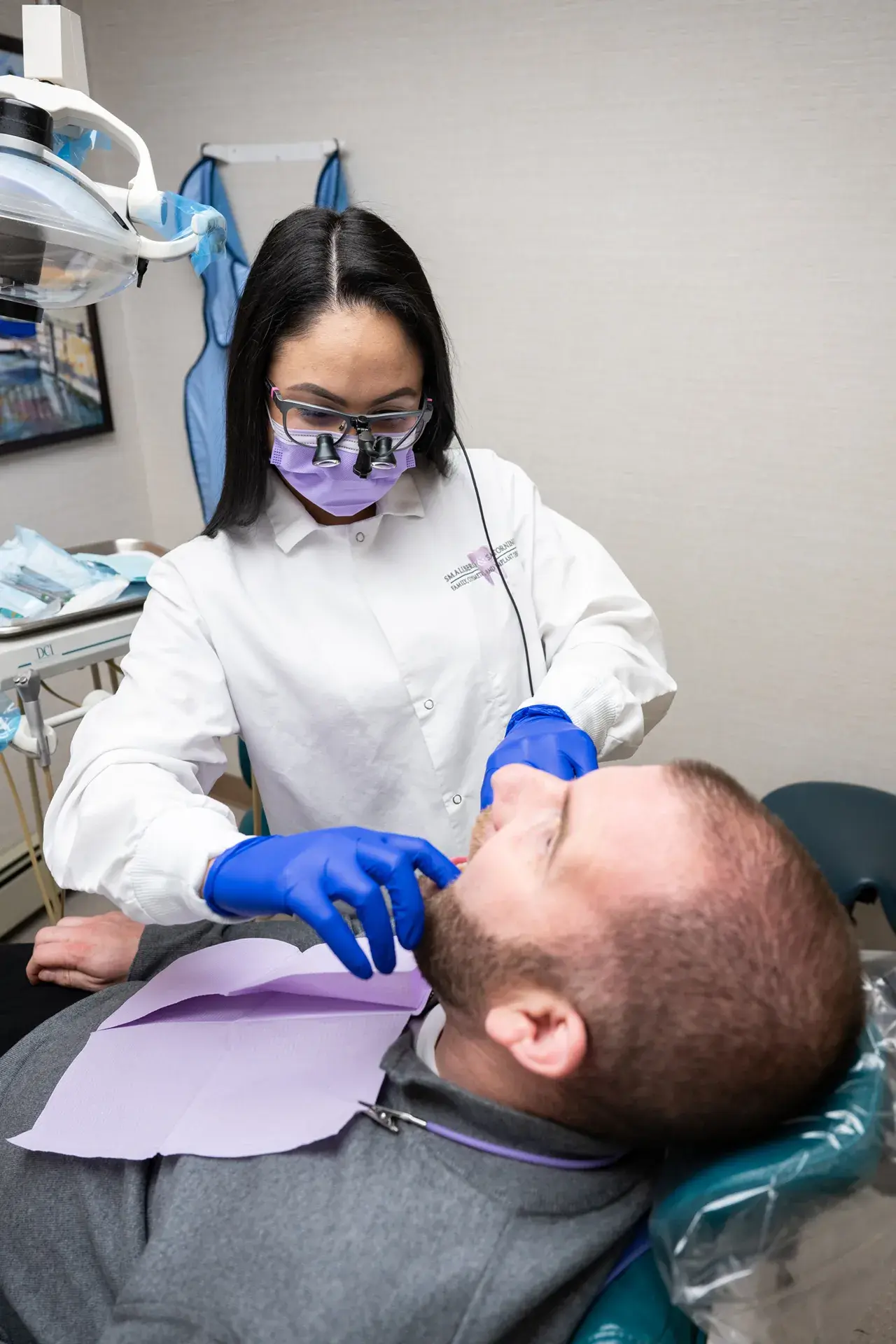 General Dentistry 2 Dentist treating patient using dental suction tool – General Dentistry in Westbury, NY