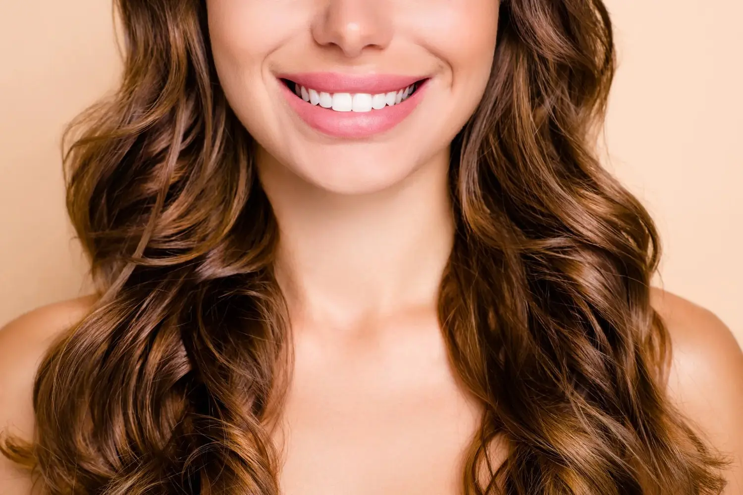 Close-up of young woman’s white smile with curly hair – Cosmetic Dentistry in Westbury, NY – Smallberg & Satornino, DDS, PLLC