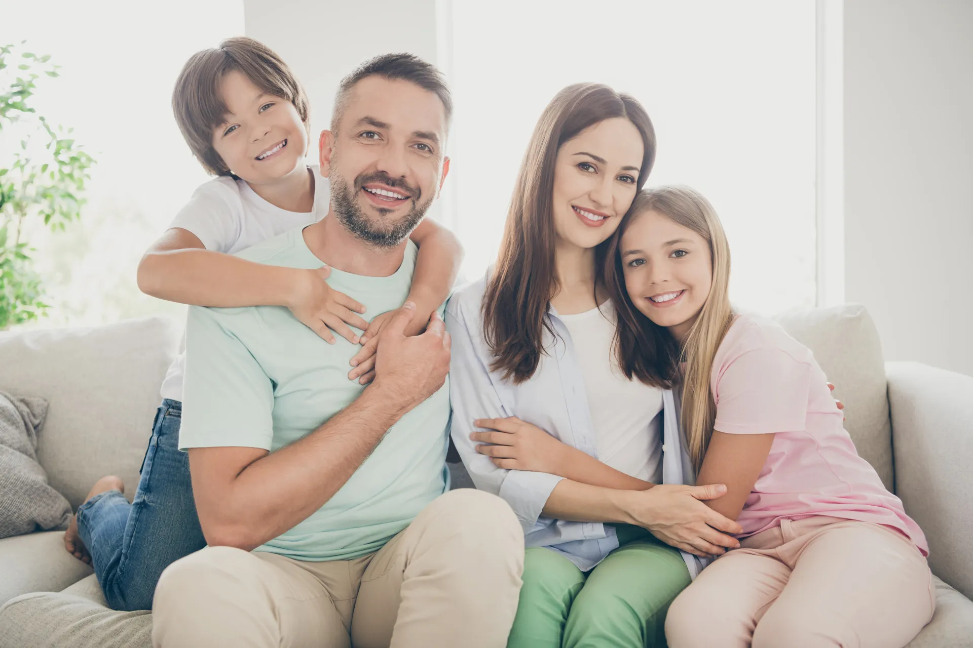 General Dentistry 1 Family smiling together on couch – Family Dentistry in Westbury, NY – Smallberg & Satornino, DDS, PLLC