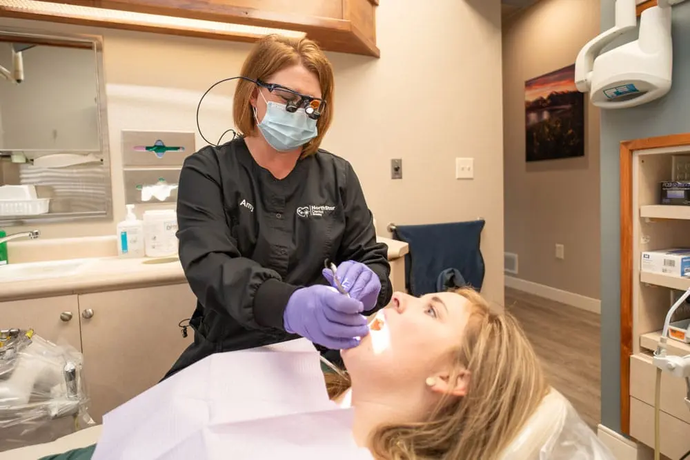Amy examining a patient's teeth at NorthStar Dental