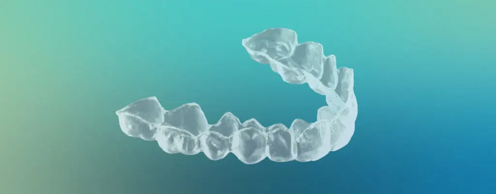 At-Home Whitening Trays | VP Dental | At-Home Teeth Whitening Clear at-home teeth whitening tray against a blue-green gradient background