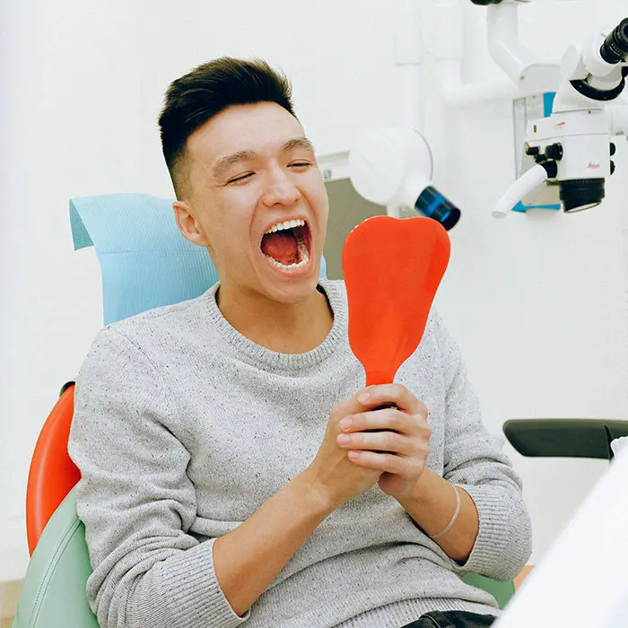 Why Are Oral Cancer Screenings Important? | VP Dental | Stop Chewing Ice patient looking at his restored smile after getting oral surgery in Raleigh, NC