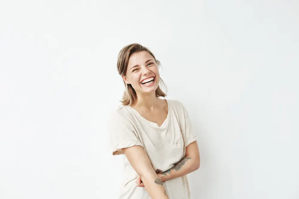 CariFree Gel | VP Dental | CariFree Gel in Raleigh A smiling woman with healthy teeth, wearing a casual beige shirt, representing the benefits of CariFree Gel for oral health