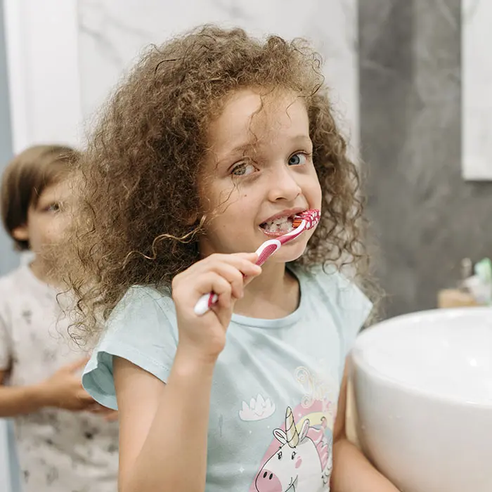 Which Kids’ Toothbrush Is Best? | VP Dental | Stop Chewing Ice Pediatric dentist in Raleigh teaching a child to brush her teeth.