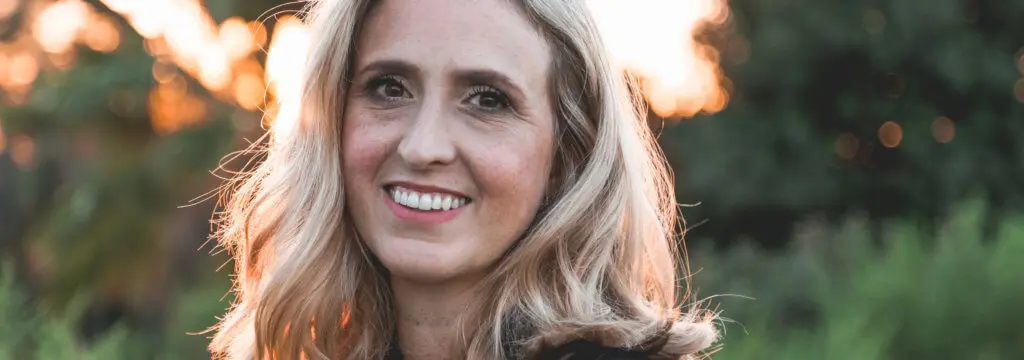 Veneers | VP Dental | veneers in Raleigh Smiling woman with blonde hair outdoors, showcasing bright, even teeth, representing the results of porcelain veneers in Raleigh