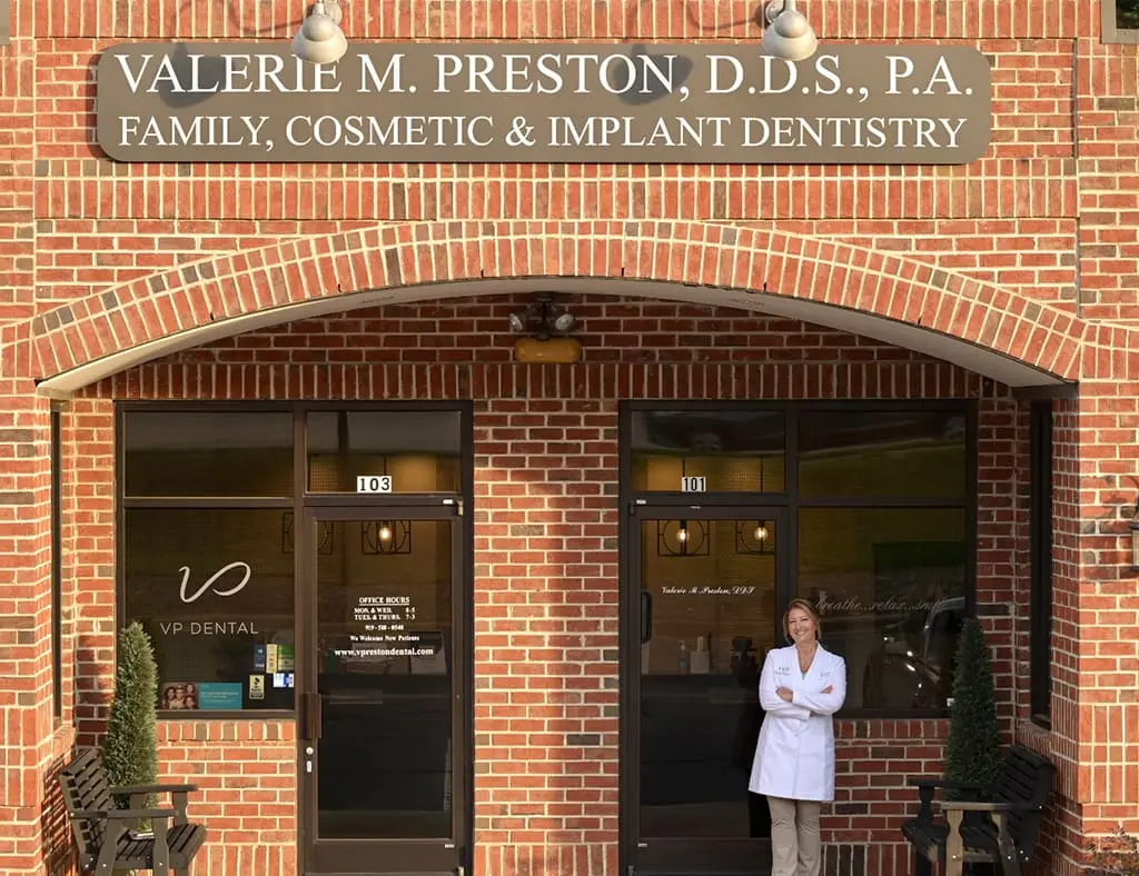A dentist standing outside a brick building of VP Dental 