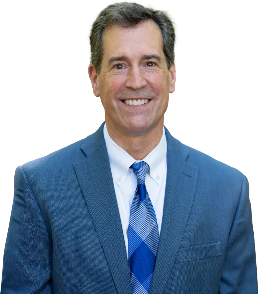 Head shot of Dr. Nordone wearing a blue suit jacket, white dress shirt, and a patterned blue tie