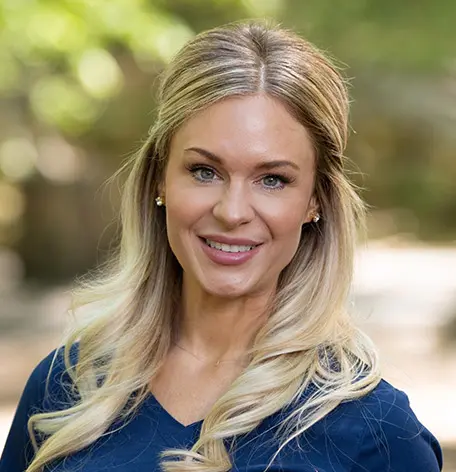 Head shot of Jennifer, Registered Dental Hygienist, smiling warmly in blue uniform