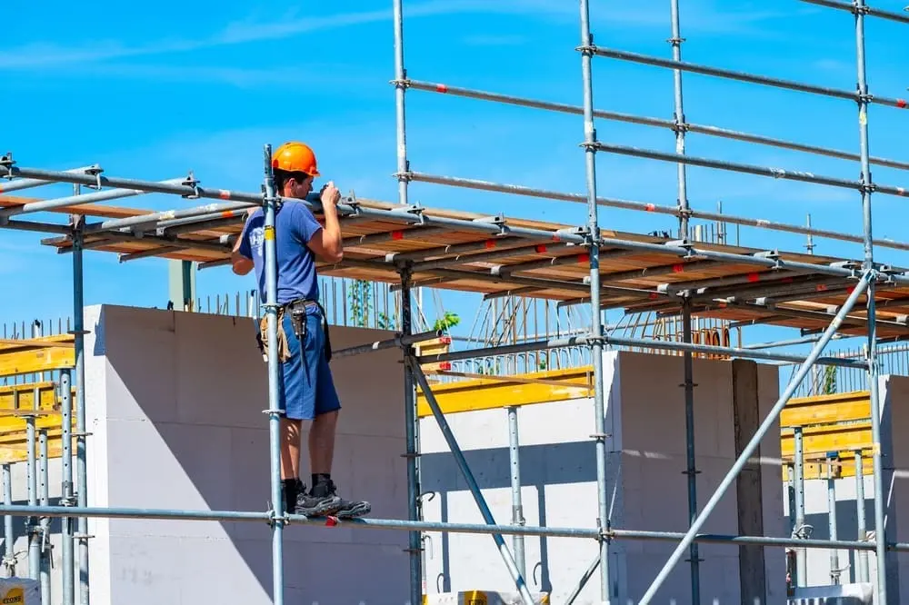 Construction worker standing on scaffolding at a building site
