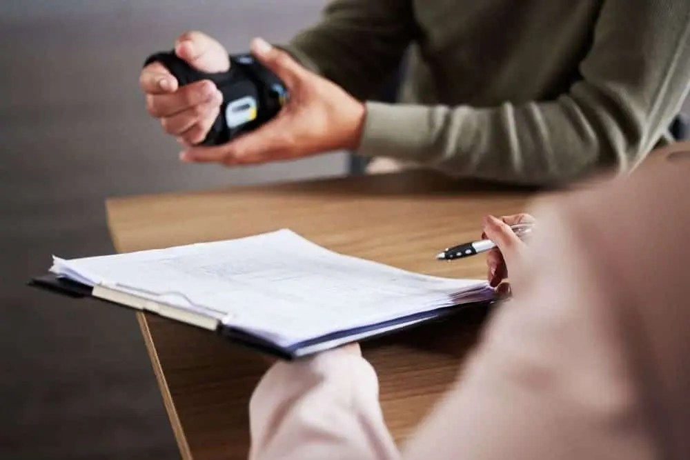 A workers' compensation lawyer in Brooklyn consulting with a client, holding documents and discussing a workplace injury claim.