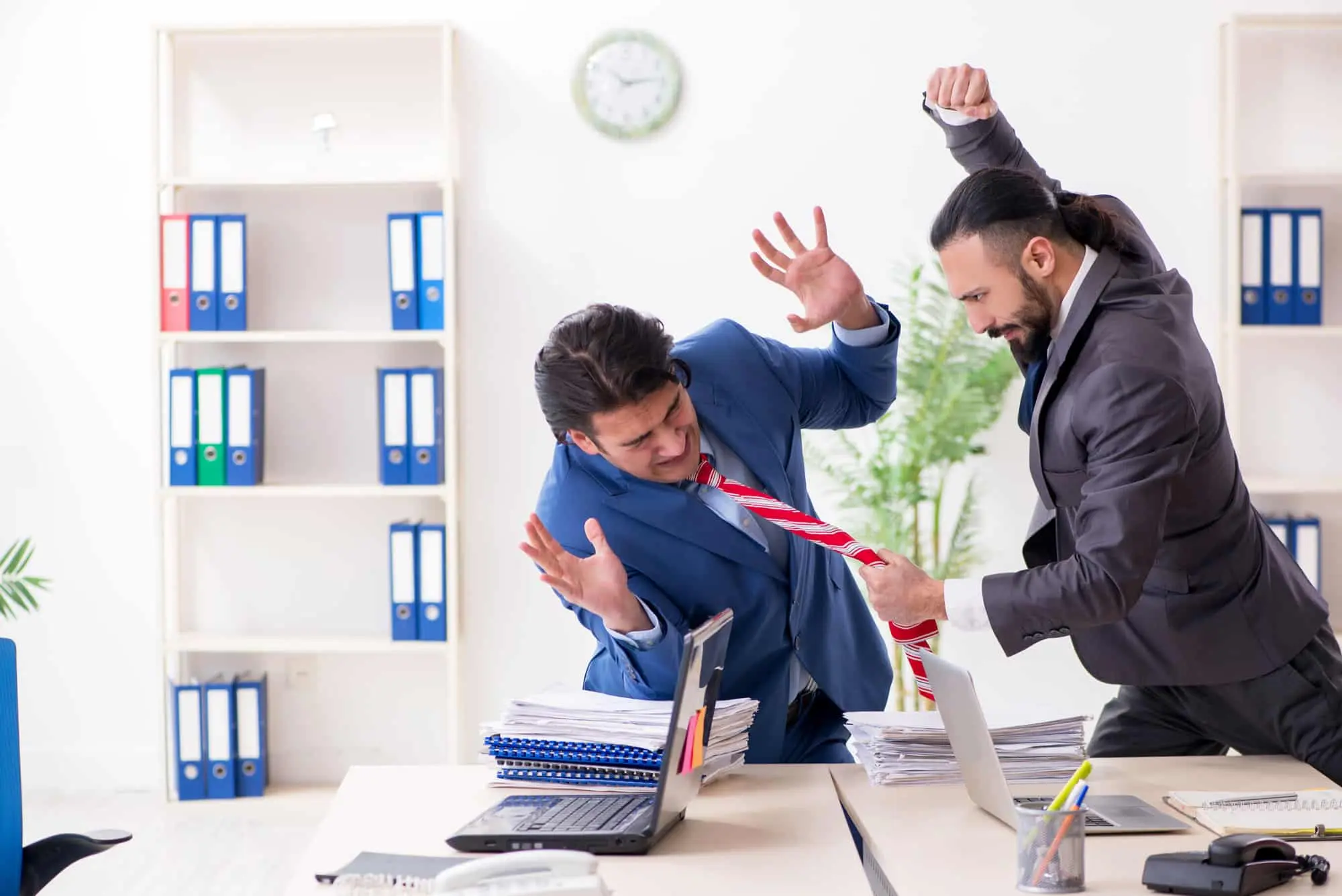 Dos colegas varones en la oficina: Violencia en el lugar de trabajo.