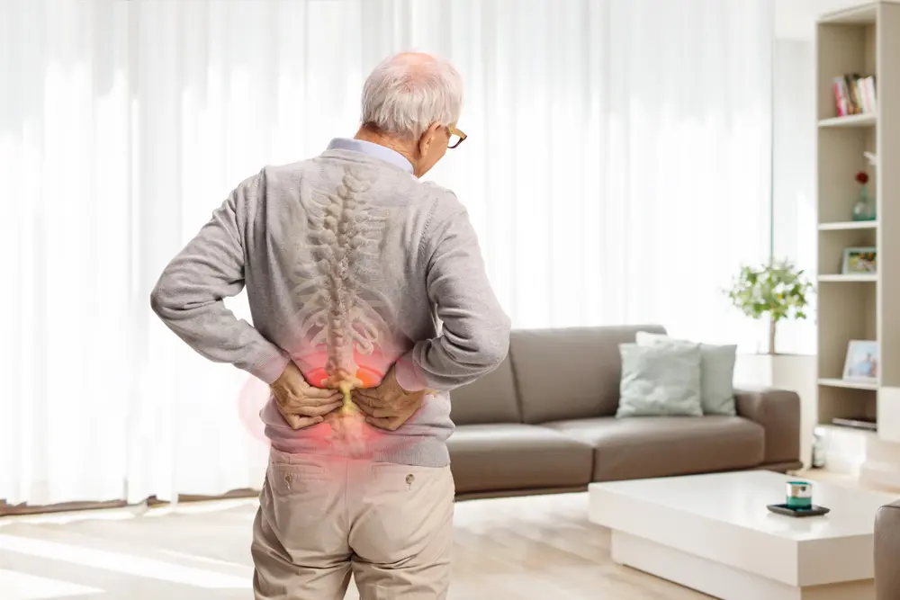 elderly man in pain holding his lower back