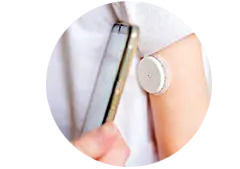 Person checking their glucos using a wearable monitor and smart phone