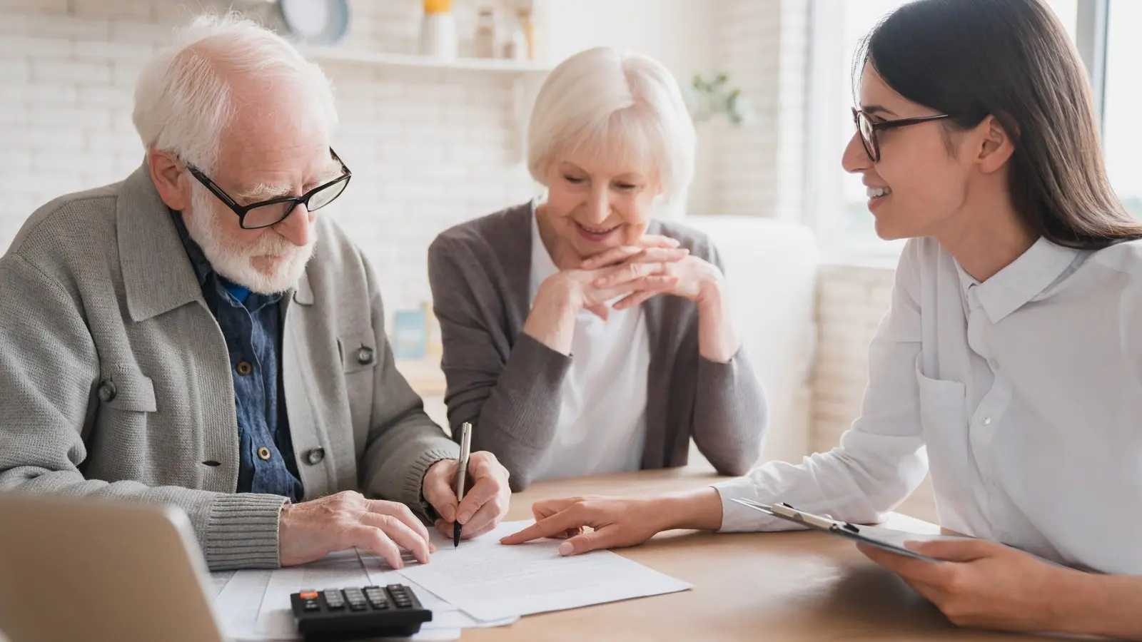 Retired couple reviewing documents at a table with their advisor