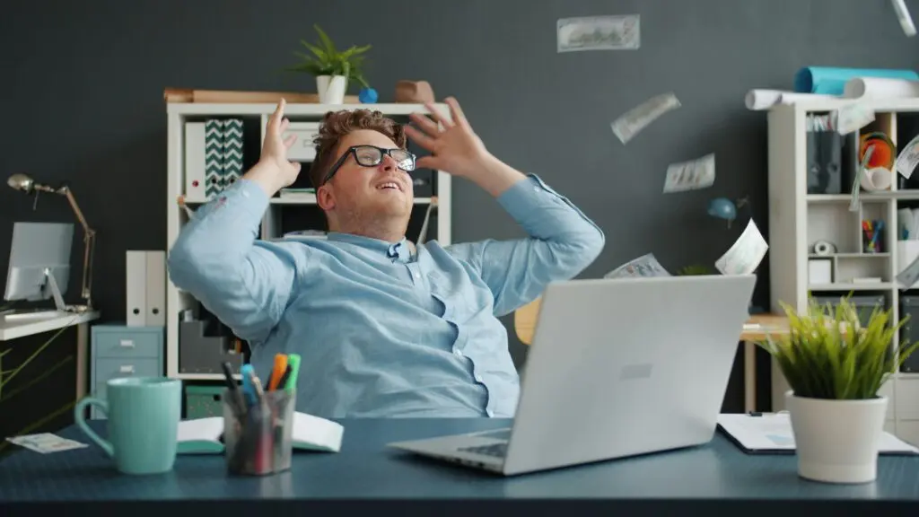 Man celebrating with money falling around him