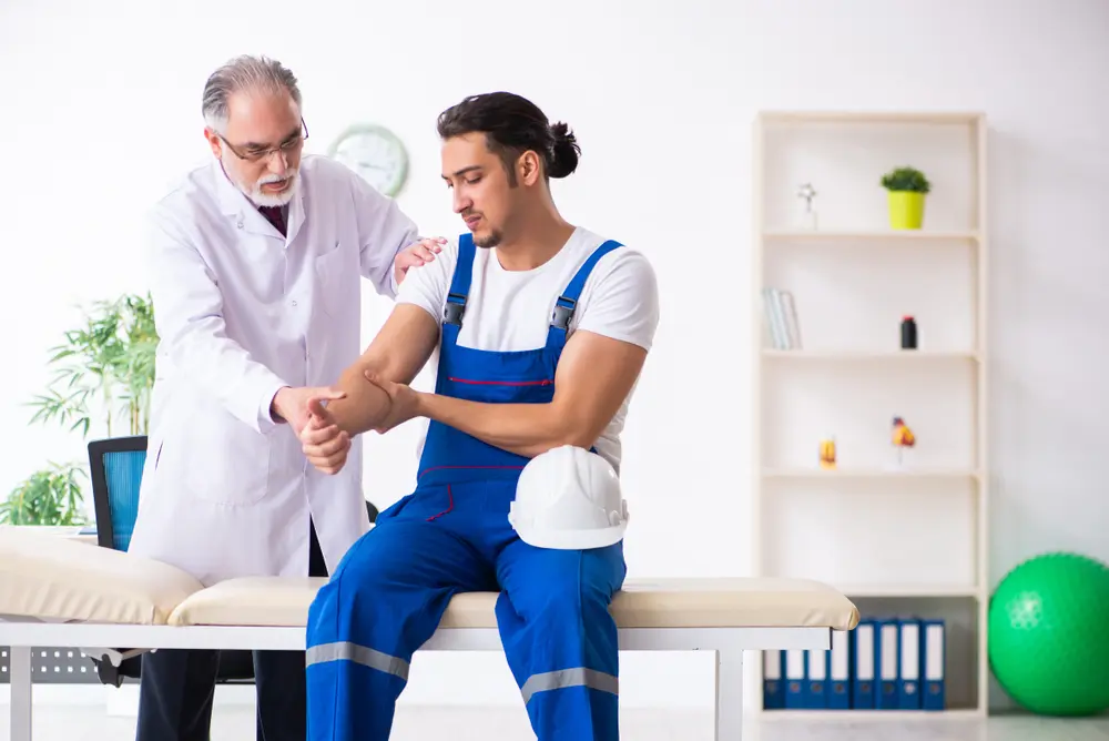 Quiropráctico examinando la muñeca de un trabajador.