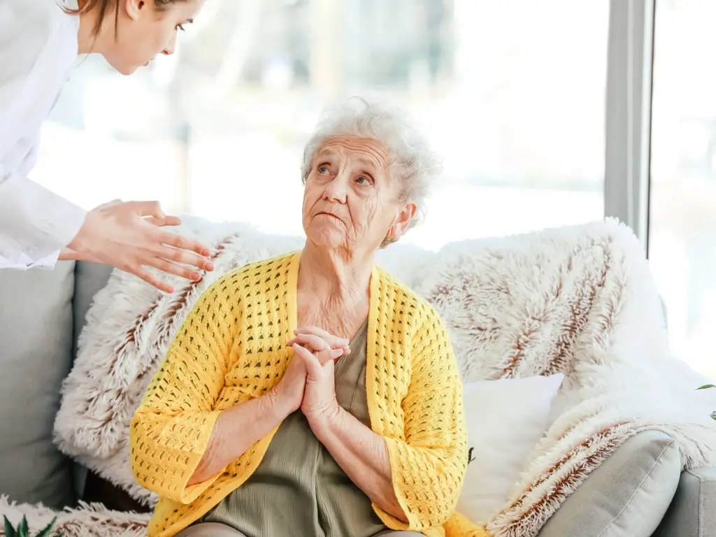 Enfermera que atiende a un paciente de edad avanzada en una residencia de ancianos