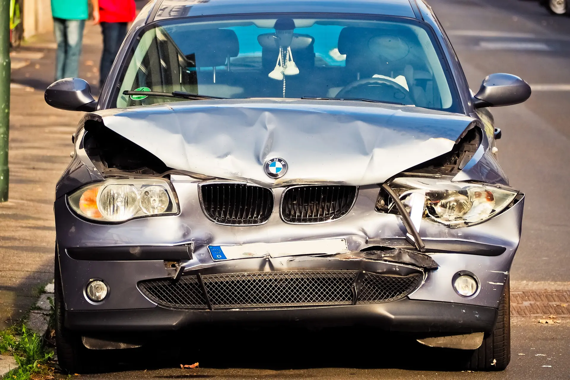 Damaged silver BMW car after accident in New York street