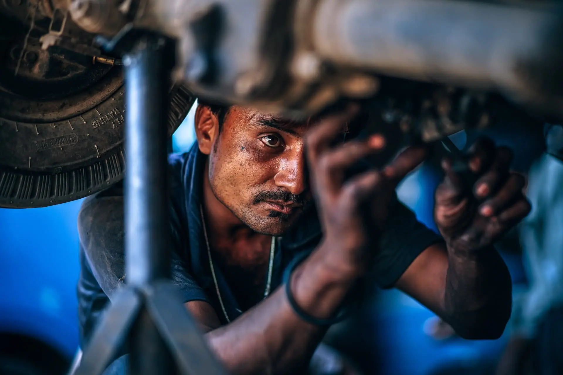 Un mecánico de coches trabajando debajo de un coche en un taller