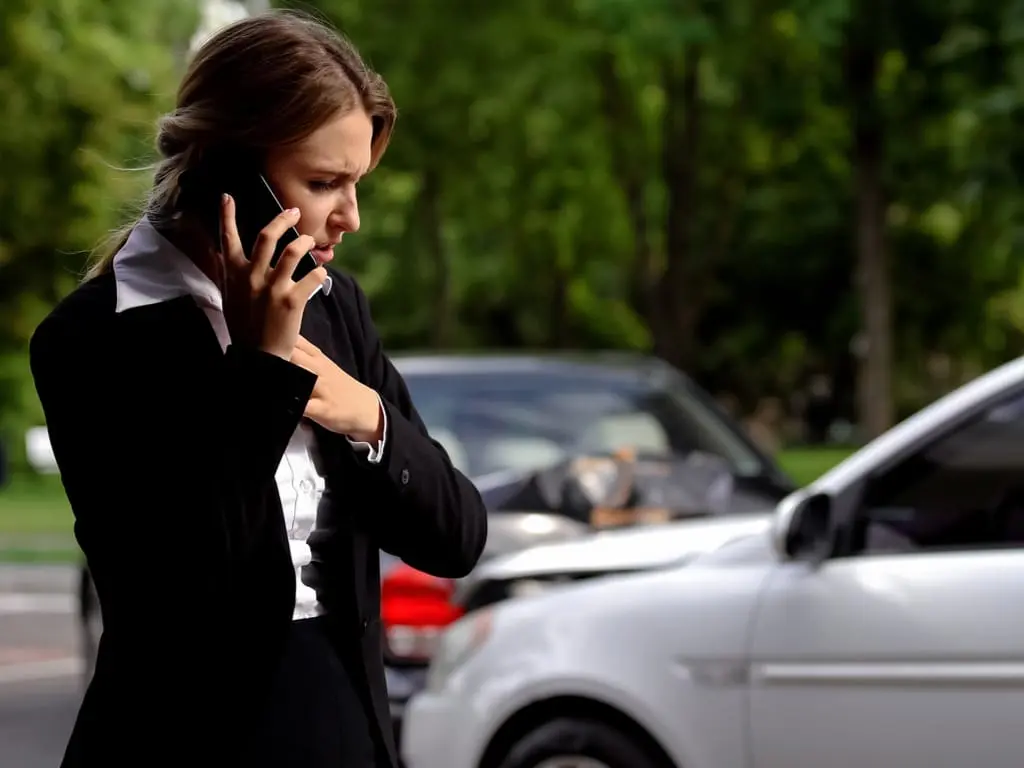 Woman on phone at car accident scene