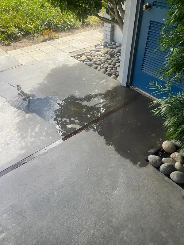 A puddle of water from a leaking tank  water heater in the closet
