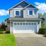 Two story house with small entrance porch and garage with driveway in Urbana, MD.