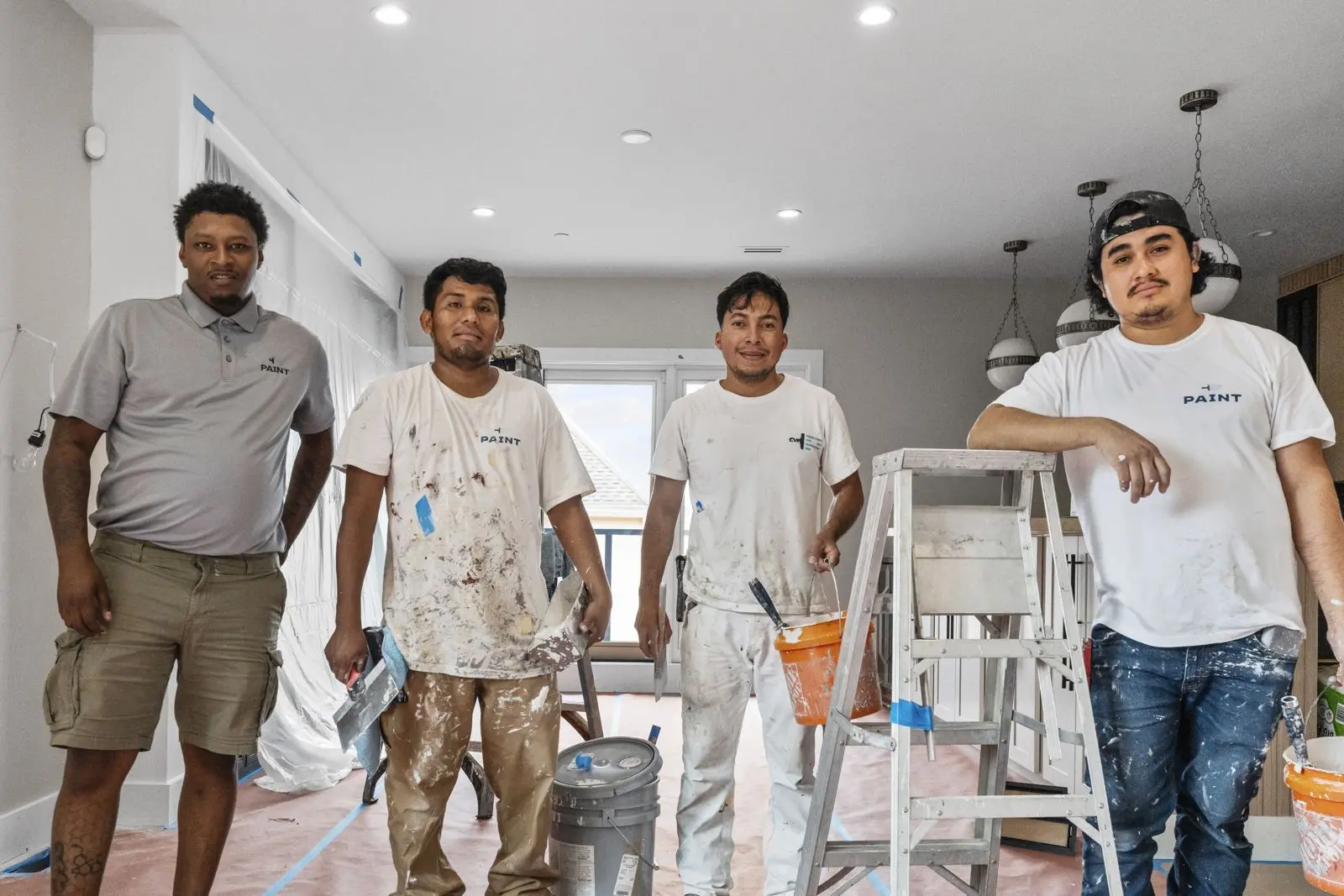 A PAINT Philadelphia crew standing in a kitchen they are painting