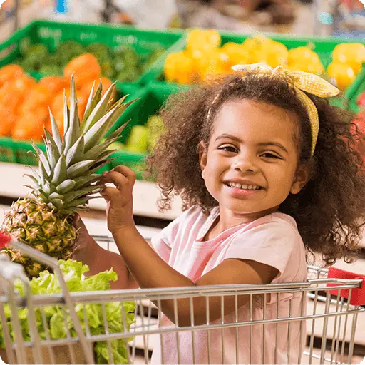 toddler in supermarket holding a pineapple