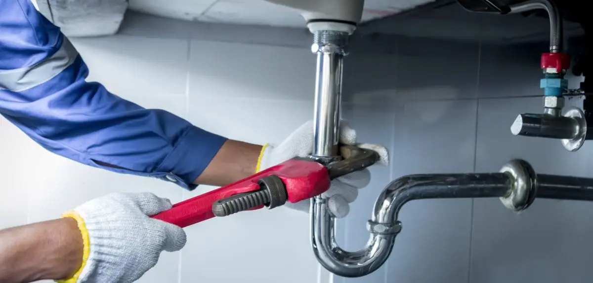 guy using wrench on pipe