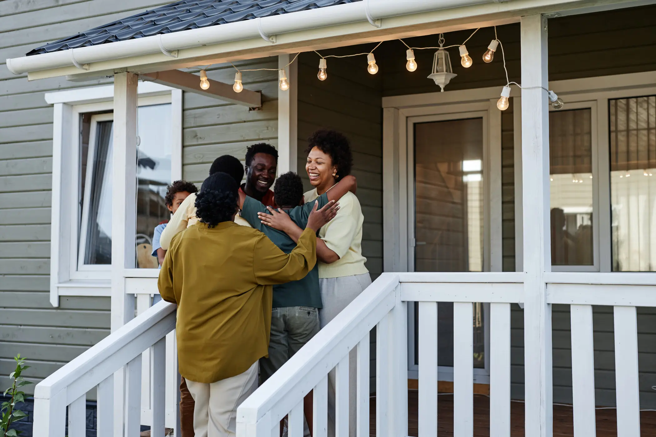family hugging outside of the house