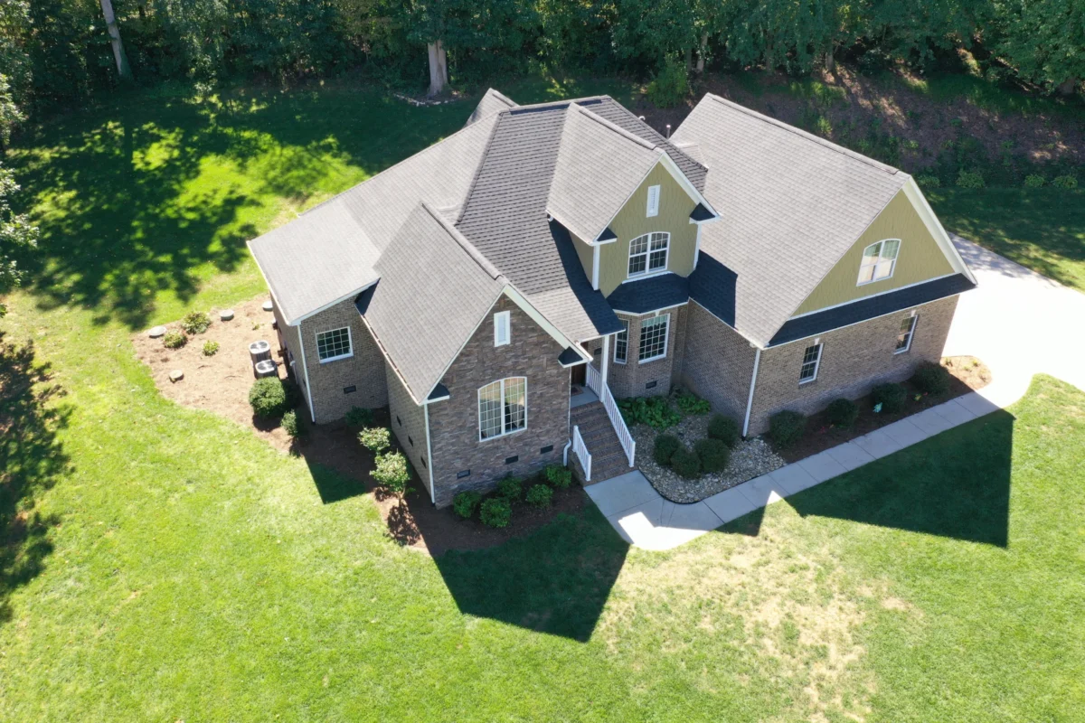 drone view of house surrounded with trees