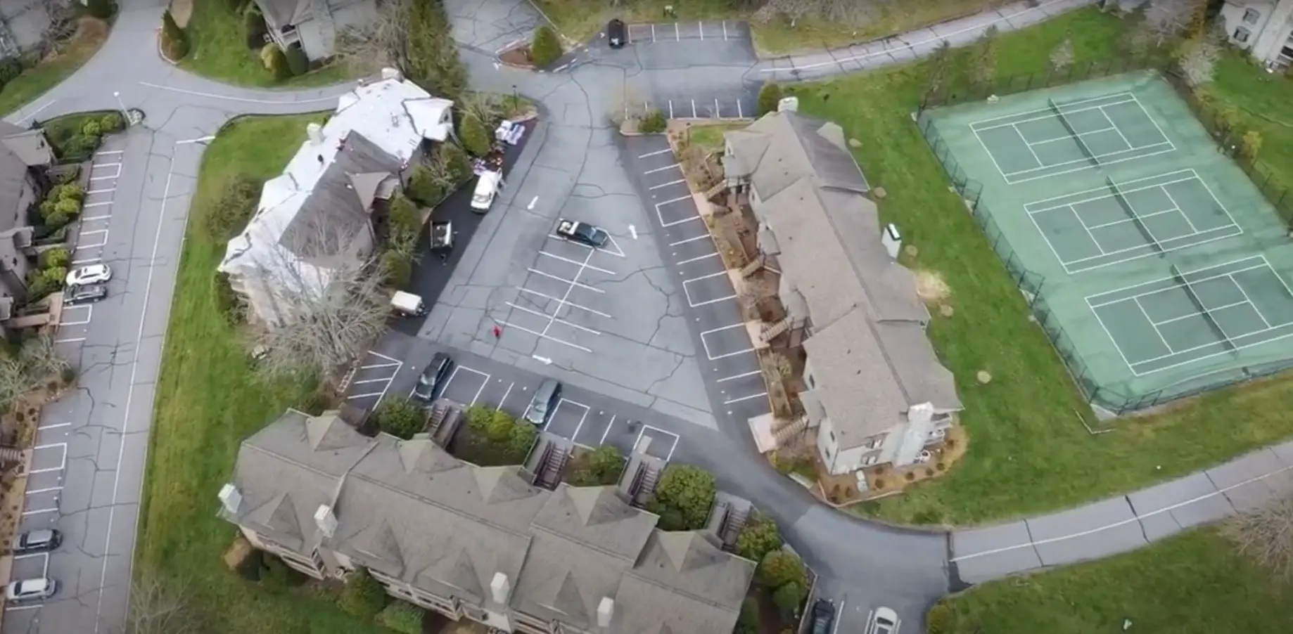 drone footage of townhouse neighborhood with tennis courts