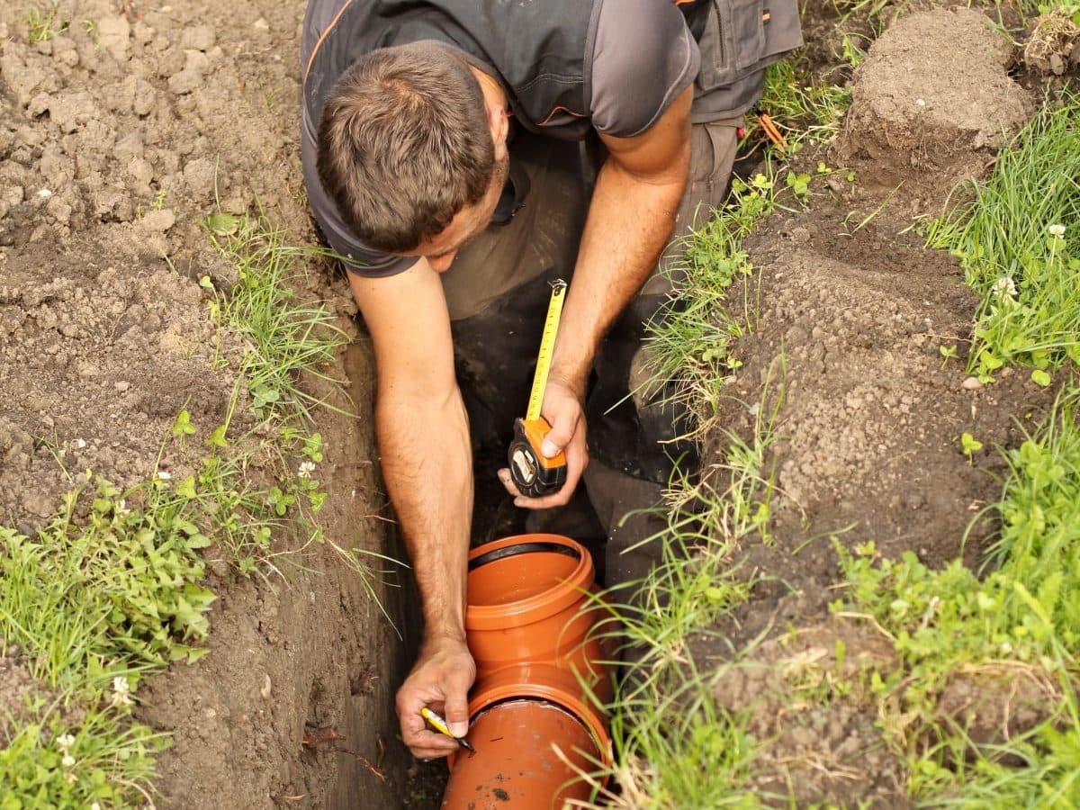 guy repairing orange sewer line
