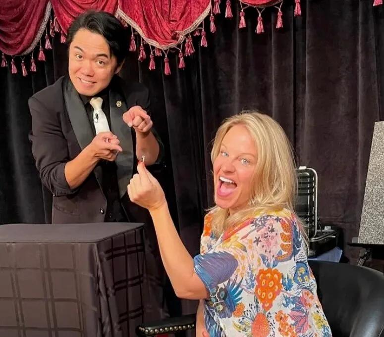 Magician performing a trick with an audience member at The Magical Mystery Show.