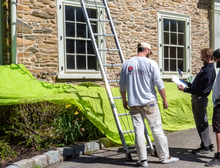 Lauro Painting crew consulting with a homeowner before starting an exterior painting project.