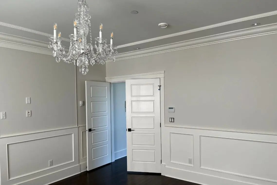 residential-interior-painting Freshly painted gray dining room with white wainscoting, crown molding and coffered ceiling detail.