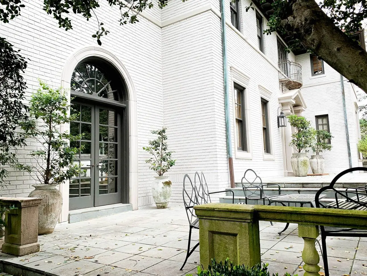 Brick home painted Sherwin-Williams Egret White, with an arched French door. Exterior by Caldwell Painting, house painter in Memphis and Nashville.