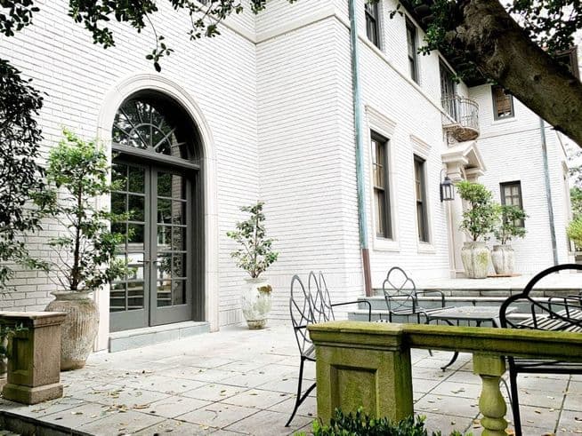 Brick home painted Sherwin-Williams Egret White, with an arched French door. Exterior by Caldwell Painting, house painter in Memphis and Nashville.