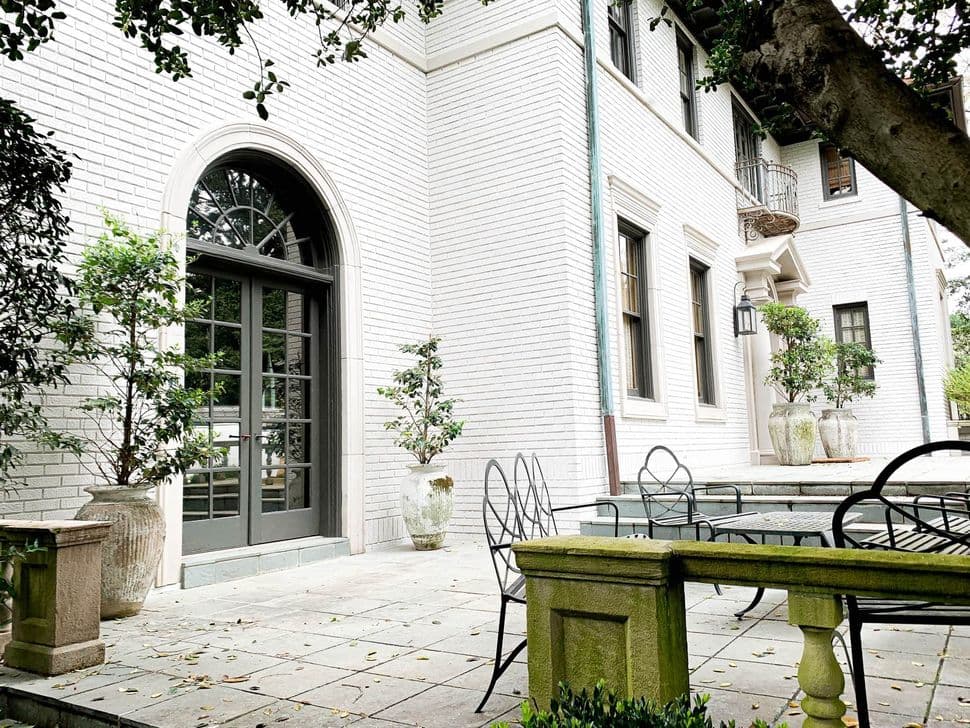 Brick home painted Sherwin-Williams Egret White, with an arched French door. Exterior by Caldwell Painting, house painter in Memphis and Nashville.