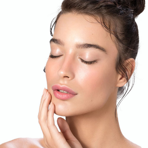 Woman with her eyes closed and one hand resting against her jaw, on a white background
