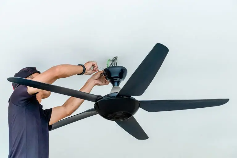 A man installing a ceiling fan. Home improvement, professional work, and technical skill concept.