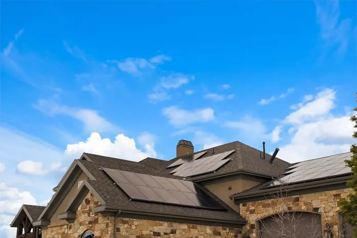 Cloudy blue sky over a home with solar panels on the pitched roof