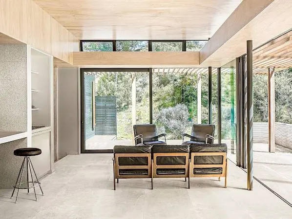 Open plan living space with child on kitchen stool, toddler running towards camera and mother sitting in chair. PEKA PEKA II HOUSE, Peka Peka - Kapiti Coast, New Zealand. Architect: HMA, 2016.
