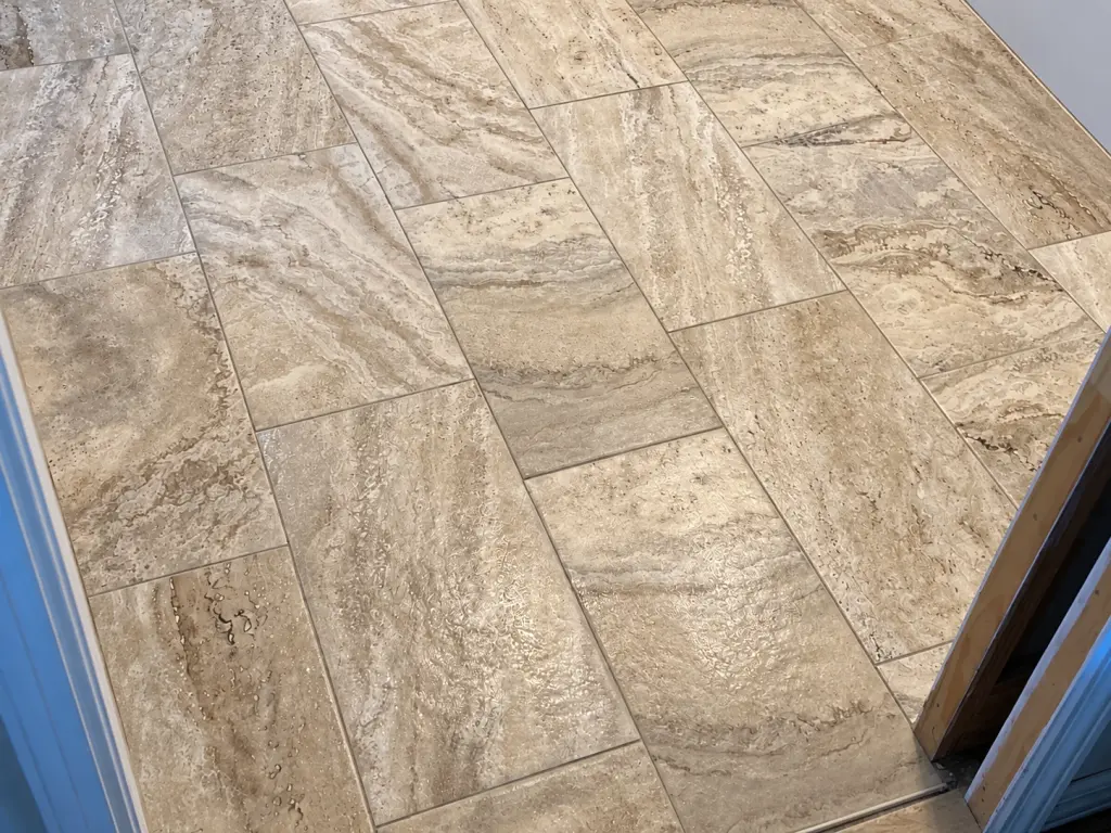 Close view of beige stone-look bathroom floor tile