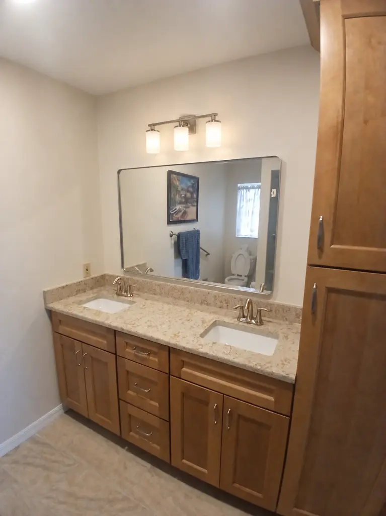 Wood-tone double vanity and tall storage cabinet in a Venice bathroom project