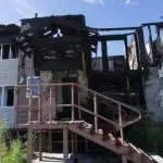 Edificio quemado con estructura dañada y exterior carbonizado, lo que ilustra el impacto de los daños causados por incendios relevantes para las reclamaciones de seguros.