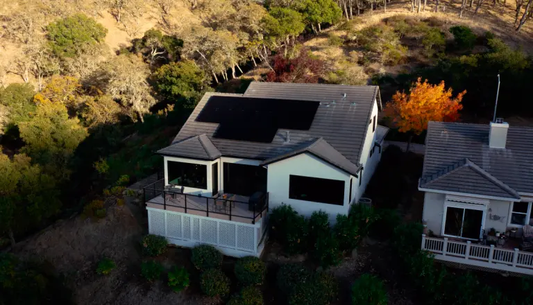 A house with newly installed solar panels surrounded by trees