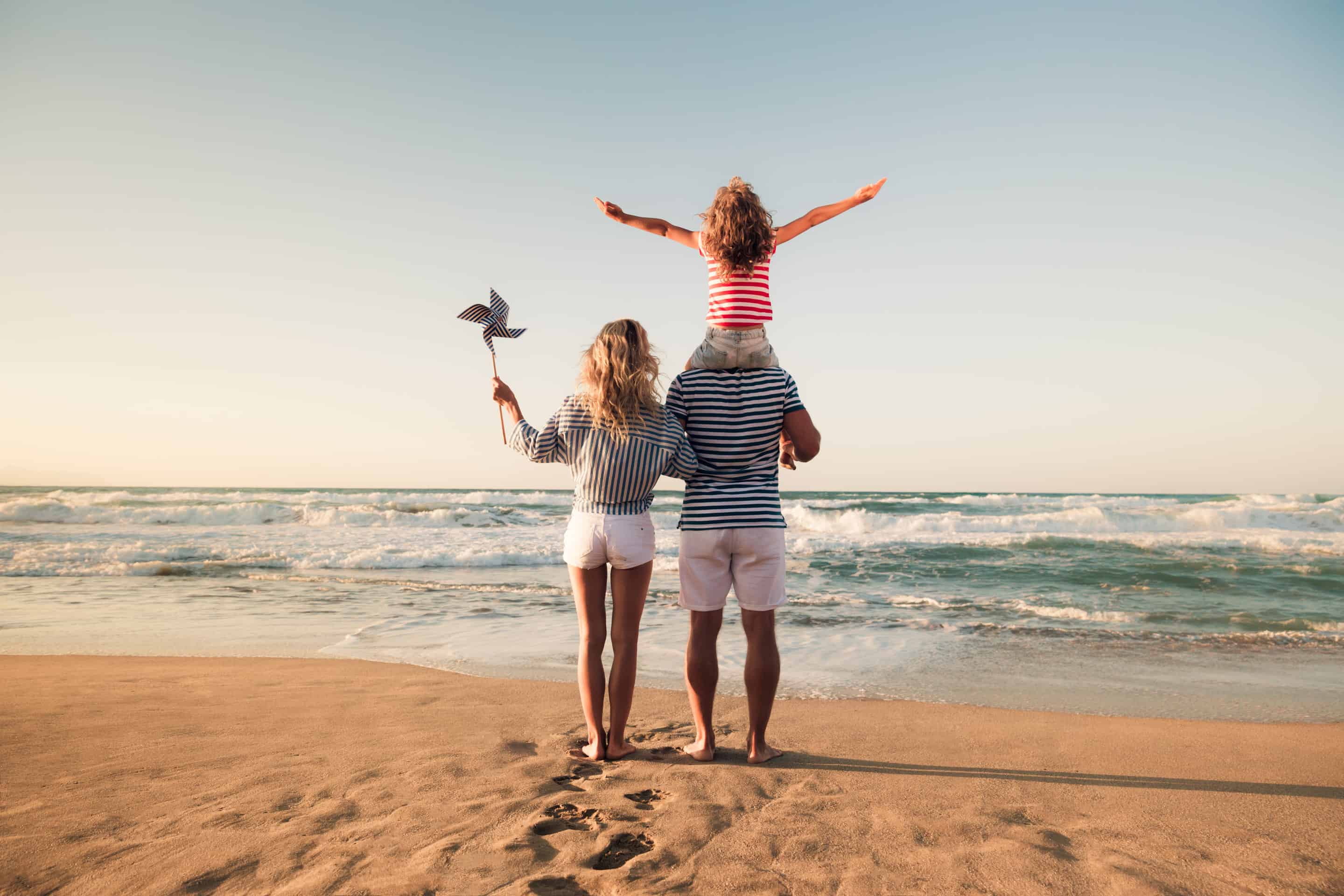 family facing ocean standing in stand
