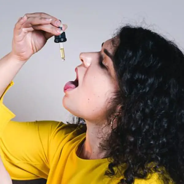 woman taking allergy medicine out of an eye dropper